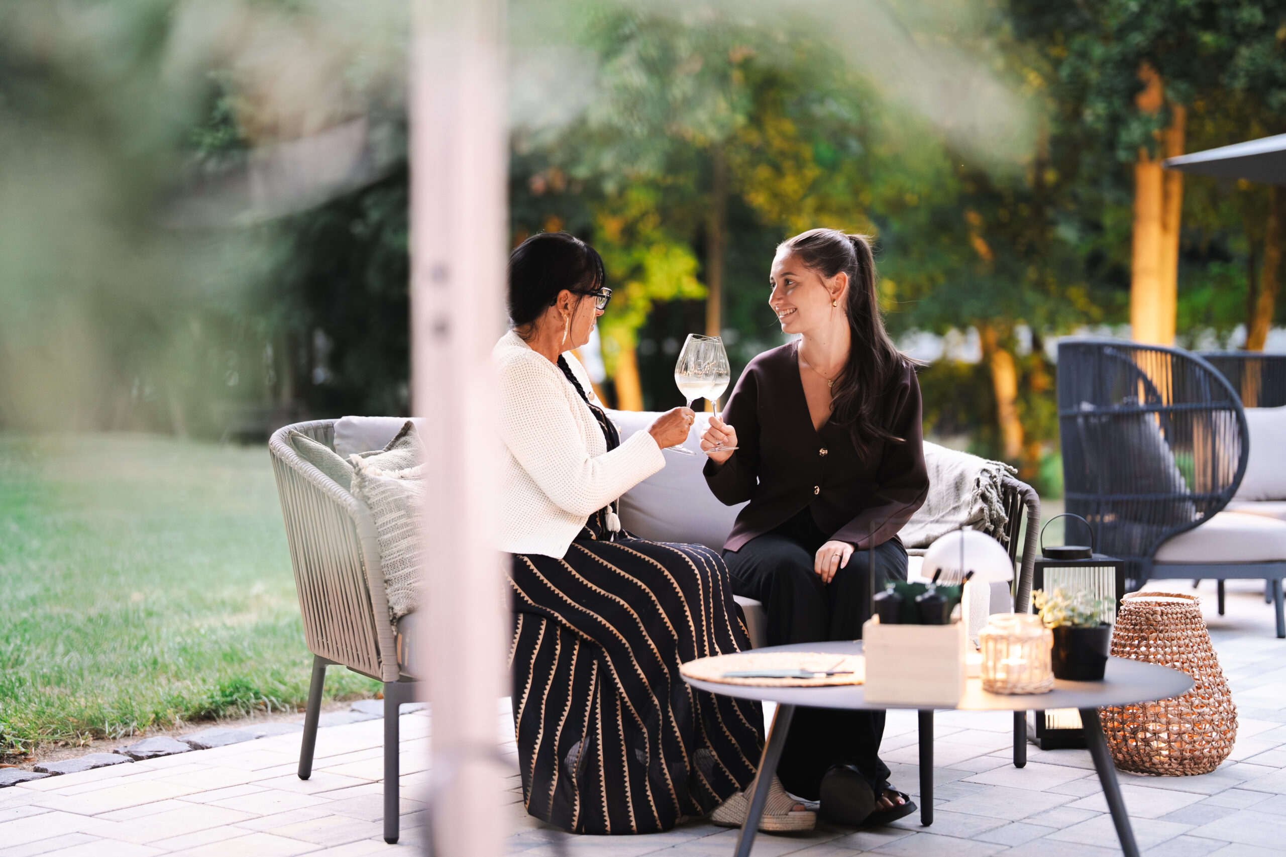 Freundinnen genießen Sommerabend mit Aperitifs auf der Hotelterrasse